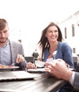 Businessman and his colleagues have lunch in a street cafe Royalty Free Stock Photo