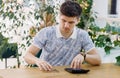 Businessman at his desk with calculator counts coins in office