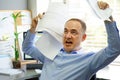 Businessman at his desk throws documents and papers into the air Royalty Free Stock Photo