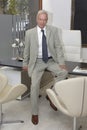 a businessman in his office sitting on table and looking at camera on white Royalty Free Stock Photo