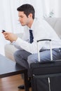 Businessman with his suitcase using mobile phone Royalty Free Stock Photo