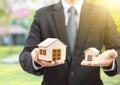 Businessman hold big and small houses on hand Royalty Free Stock Photo