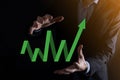 Businessman hold drawing on screen growing graph, arrow of positive growth icon.pointing at creative business chart with upward Royalty Free Stock Photo