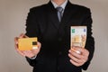Businessman hold 50 EURO EUR money and credit card as business, trade, currency, investment and income concept