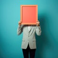 Businessman holding an empty coral frame hiding his face. Royalty Free Stock Photo