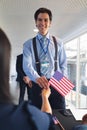 Businessman holding an American flag at conference registration table Royalty Free Stock Photo