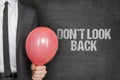 Businessman Holding Balloon By Dont Look Back Text On Blackboard Royalty Free Stock Photo