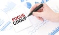 Businessman holding a black marker, notepad with text FOCUS GROUP, business concept Royalty Free Stock Photo