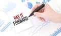Businessman holding a black marker, notepad with text PAY IT FORWARD,business concept Royalty Free Stock Photo