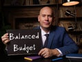 Businessman holding a blank notepad. Business concept about Balanced Budget with phrase on the sheet