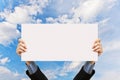 Businessman holding blank sign and hand in sky