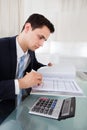 Businessman holding calculating expense in office Royalty Free Stock Photo