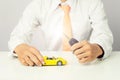 Businessman holding a car keys and miniature car model, Auto business and financial concept