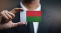 Businessman Holding Card of Madagascar Flag