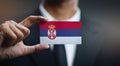 Businessman Holding Card of Serbia Flag