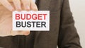 businessman holding a card with text BUDGET BUSTER