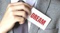 Businessman holding a card with text DREAM