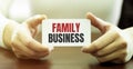 Businessman holding a card with text FAMILY BUSINESS Royalty Free Stock Photo