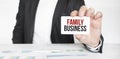 Businessman holding a card with text FAMILY BUSINESS Royalty Free Stock Photo