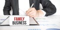 Businessman holding a card with text FAMILY BUSINESS Royalty Free Stock Photo