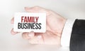 Businessman holding a card with text FAMILY BUSINESS Royalty Free Stock Photo