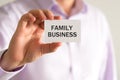 Businessman holding card with text FAMILY BUSINESS