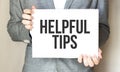 businessman holding a card with text HELPFUL TIPS Royalty Free Stock Photo
