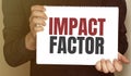 Businessman holding a card with text IMPACT FACTOR Royalty Free Stock Photo