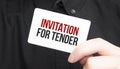 Businessman holding a card with text INVITATION FOR TENDER,business concept