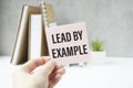 holding a card with text LEAD BY EXAMPLE Royalty Free Stock Photo
