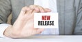 Businessman holding a card with text NEW RELEASE Royalty Free Stock Photo