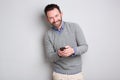 Businessman holding cellphone against gray background Royalty Free Stock Photo