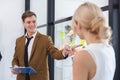 Businessman holding clipboard hands talking meeting with businesswoman in coworking office. businessperson brainstorming strategy