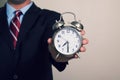 A businessman holding a clock