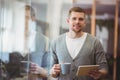 Businessman holding coffee cup with digital tablet in office Royalty Free Stock Photo