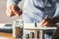 businessman holding coins putting in glass. concept saving money and finance