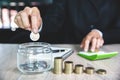 Businessman holding coins putting in glass jar,  step of coins stacks on working table, concept saving money for finance Royalty Free Stock Photo