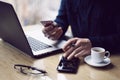 Businessman holding credit card in hand and using smartphone,laptop computer at the wooden table.Blurred background Royalty Free Stock Photo