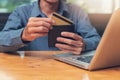 Businessman holding credit cart to shopping online with computer laptop in cafe