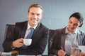 Businessman holding cup and smiling at camera Royalty Free Stock Photo