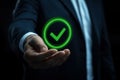 Businessman holding a digital icon of a checkmark with quality assurance and certification symbols, standard compliance