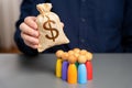 Businessman holding dollar money bag over group of people figurines.