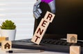 Businessman holding the down arrow on wooden blocks with the word Rate and house. Low interest in mortgages. Reducing interest Royalty Free Stock Photo