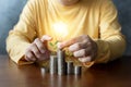 Businessman holding energy-saving lamps with plants growing on coins and trees growing on coins, business start-up ideas, and Royalty Free Stock Photo