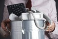 Businessman Holding Garbage Can With Obsolete Office Equipment