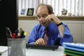 Businessman holding glasses and looking at computer, horizontal Royalty Free Stock Photo