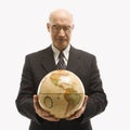 Businessman holding globe.