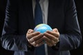 Businessman holding a globe in his hands on a dark background Royalty Free Stock Photo