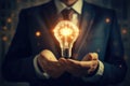 Businessman holding a glowing light bulb in his hand. Idea and innovation concept, Businessman, set against a blurred background, Royalty Free Stock Photo