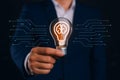 Businessman holding a glowing lightbulb with a brain symbol representing creative ideas Royalty Free Stock Photo